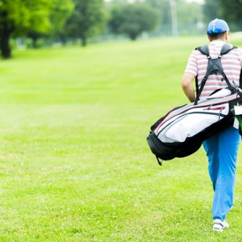 Golfer carrying his equipment on a beautiful sunny day